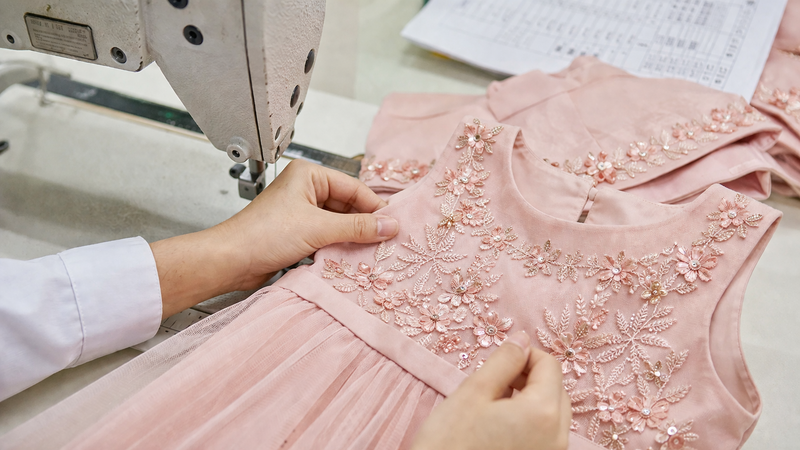 How to Inspect Bulk Kids Dresses: An AQL 2.5 Inspection Guide Close-up of kids clothing stitching quality check